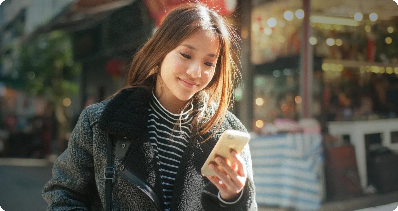 一位女士在城市中查看手机消息